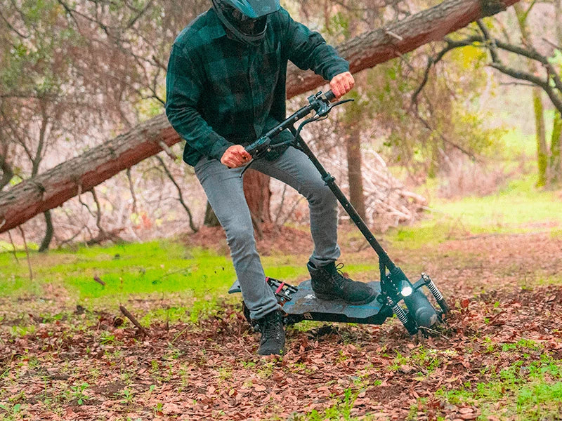 A RoadRunner electric scooter being ridden on a wooded trail